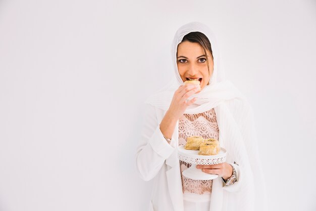 Concepto de eid con mujer sujetando pasteles árabes