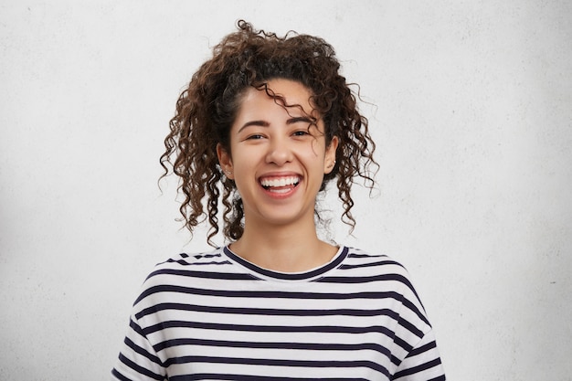 Concepto de emociones positivas. Mujer joven feliz emocional con cabello nítido, apariencia atractiva