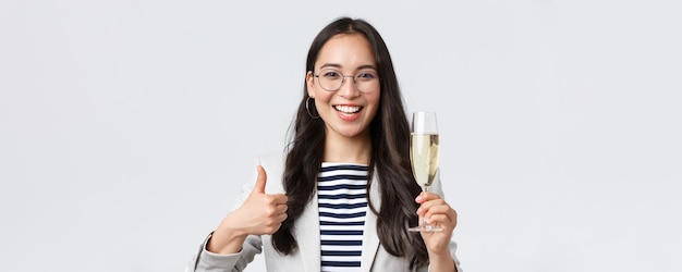 Concepto de empresaria exitosa de finanzas empresariales y empleo Mujer de negocios asiática feliz celebrando una fiesta en la oficina bebiendo champán y mostrando pulgares hacia arriba