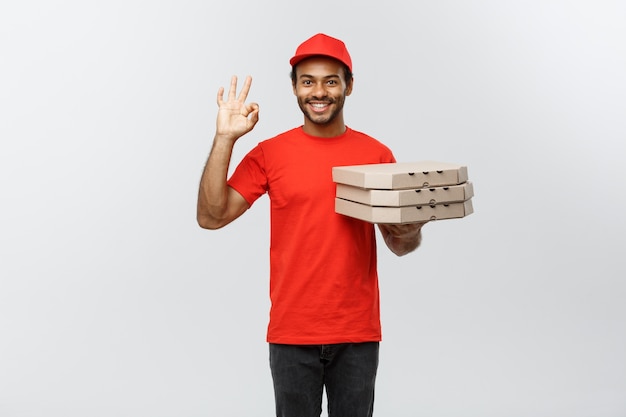 Concepto de entrega - Retrato de Handsome African American Pizza hombre de entrega. Aislado en el estudio de fondo gris. Espacio De La Copia.