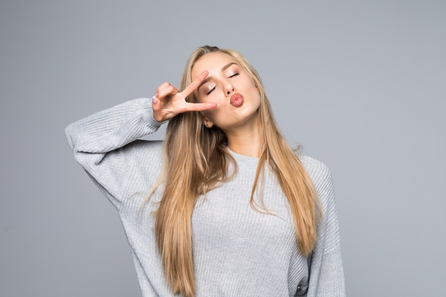 Concepto de entretenimiento de personas de boca abierta. Cerrar retrato de juguetón emocionado divertido alegre positivo optimista con sonrisa dentuda chica mostrando signo v aislado sobre fondo gris espacio de copia