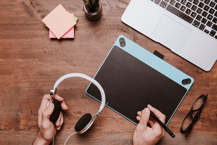 Foto gratuito concepto de escritorio de madera con manos escribiendo en tableta de diseño y sujetando casco