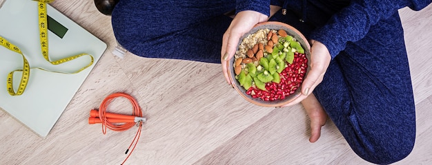 Concepto de estilo de vida saludable y fitness. La mujer está descansando y comiendo una avena saludable después de un entrenamiento. Bandera. Vista superior.