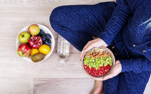 Concepto de estilo de vida saludable y fitness. La mujer está descansando y comiendo una avena saludable después de un entrenamiento. Vista superior.