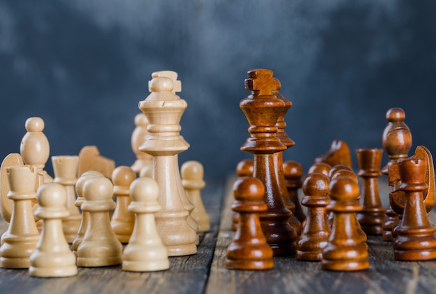 Concepto de estrategia empresarial con figuras de ajedrez en superficie oscura y de madera