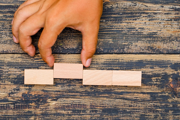 Concepto de estrategia empresarial sobre fondo de madera plana lay. mano tirando bloque de madera.