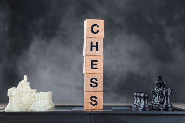 Concepto de estrategia empresarial con tablero de ajedrez y figuras, cubos de madera