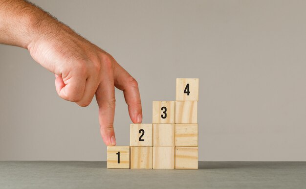 Concepto de estrategia empresarial en vista lateral de la pared gris y blanco. Hombre poniendo los dedos en las escaleras.