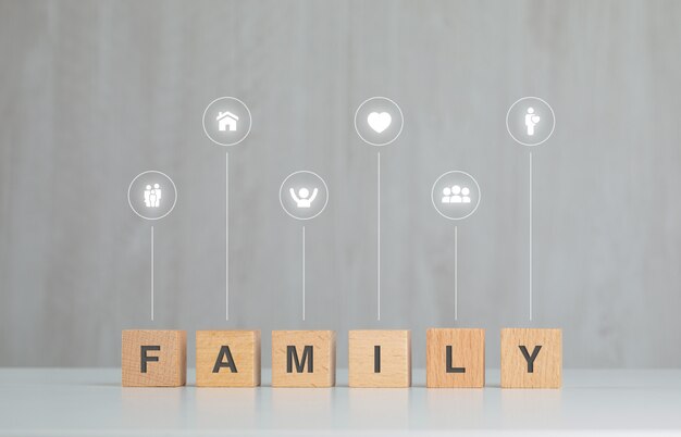 Concepto de familia con cubos de madera, iconos en vista lateral de la mesa gris y blanco.