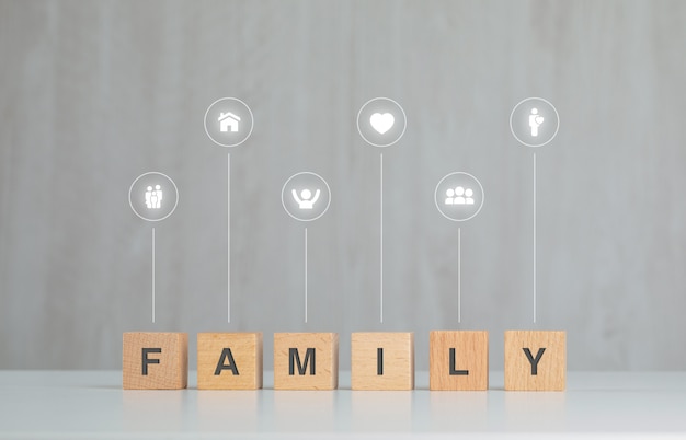 Concepto de familia con cubos de madera, iconos en vista lateral de la mesa gris y blanco.