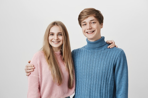 Concepto de familia o hermanos. Chica y chico sonriendo y abrazando