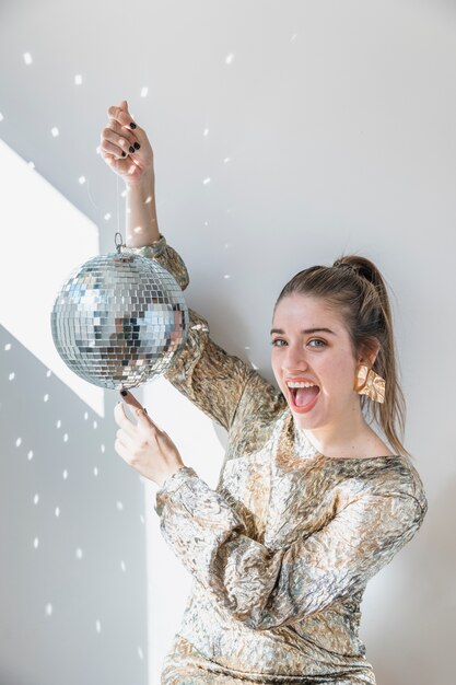 Concepto de fiesta de año nuevo con chica sujetando bola de discoteca