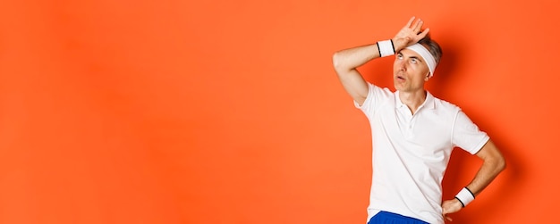 Foto gratuita concepto de fitness deportivo y retrato de estilo de vida de un atleta masculino molesto que pone los ojos en blanco y mira con la palma de la mano