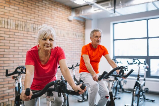 Concepto de fitness con gente mayor en bicicleta estático