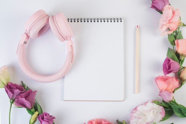 Concepto de flores con libreta y auriculares