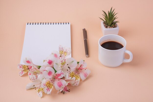 Concepto de flores con libreta y taza de café