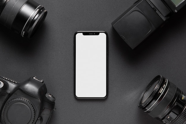 Concepto de fotografía con accesorios de cámara y teléfono inteligente en el medio