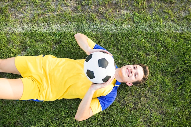 Concepto de fútbol de amateur con hombre tumbada tirando pelota