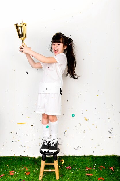 Concepto de fútbol con chica celebrando con trofeo