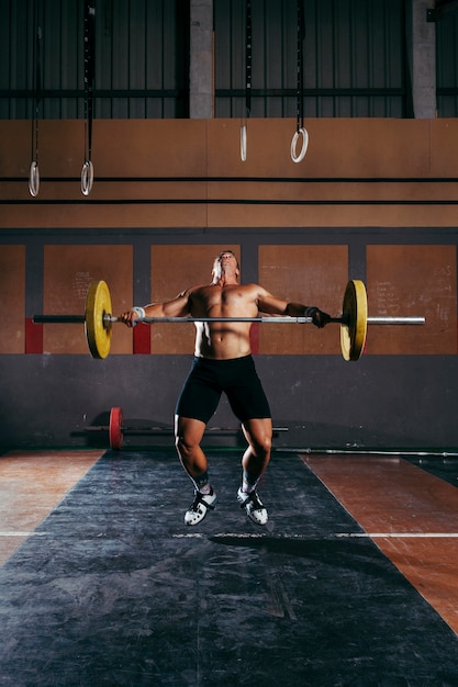 Concepto de gimnasio con hombre levantando barra de pesas