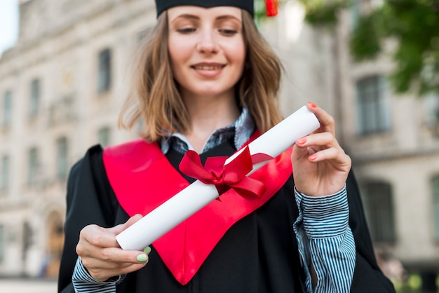 Concepto de graduación con chica sujetando su diploma