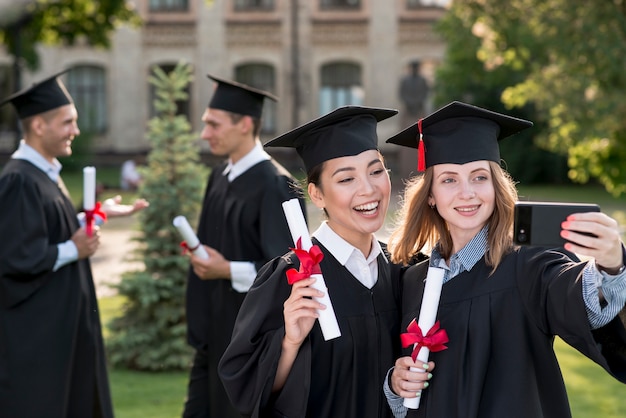 Concepto de graduación con chicas haciendo un selfie