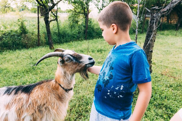 Concepto de granja con niño y cabra
