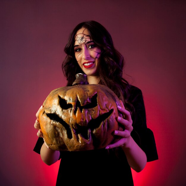 Concepto de halloween con chica sujetando calabaza