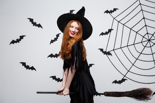 Foto gratuita concepto de halloween feliz bruja elegante disfruta jugando con escoba