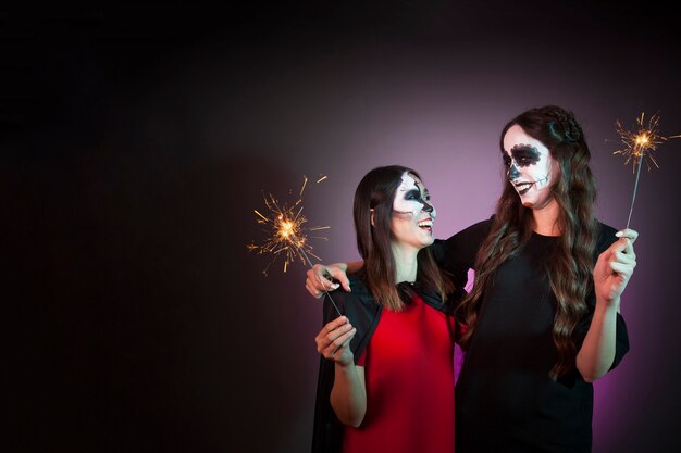 Concepto de halloween con mujeres sujetando bengalas