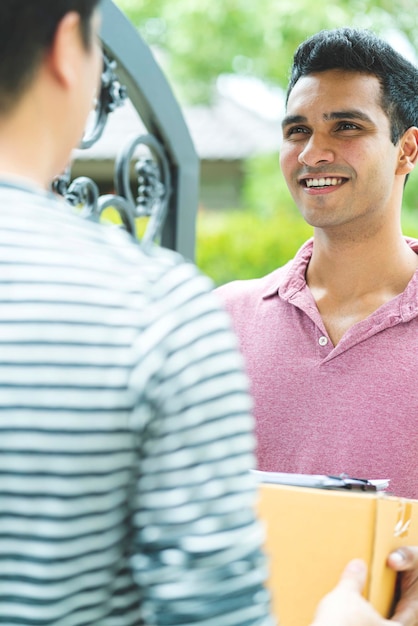 Foto gratuita concepto de ideas de entrega producto de paquete de mango de mensajero indio al cliente con felicidad y entrada alegre a la puerta de la casa