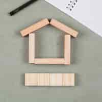 Foto gratuita concepto inmobiliario con bloques de madera, cuaderno, pluma en primer plano de fondo gris.