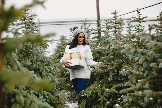 Concepto de invierno. Mujer con un suéter gris. Vendedora de Árbol de Navidad.