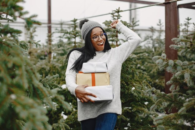 Concepto de invierno. Mujer con un suéter gris. Vendedora de Árbol de Navidad.