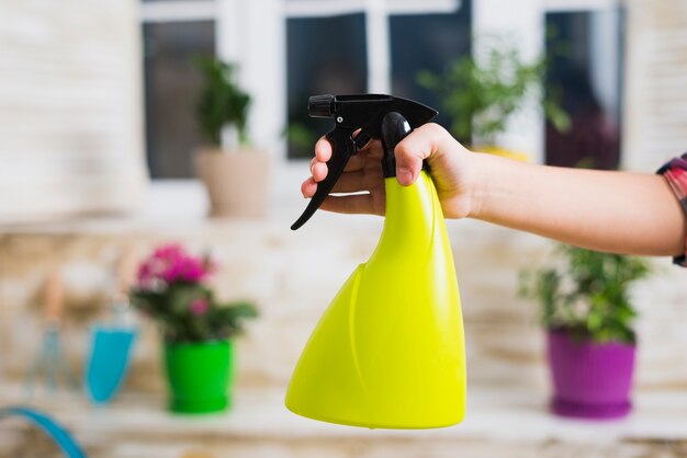 Concepto de jardinería con mano sujetando botella de spray