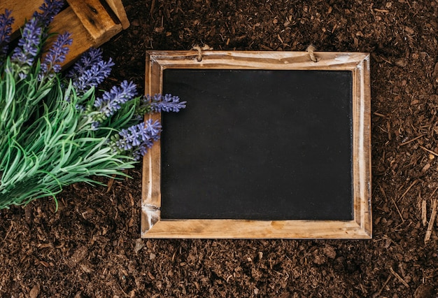 Foto gratuita concepto de jardinería con pizarra en tierra