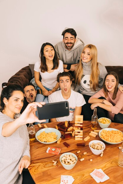 Concepto de juego de mesa con amigos posando para selfie