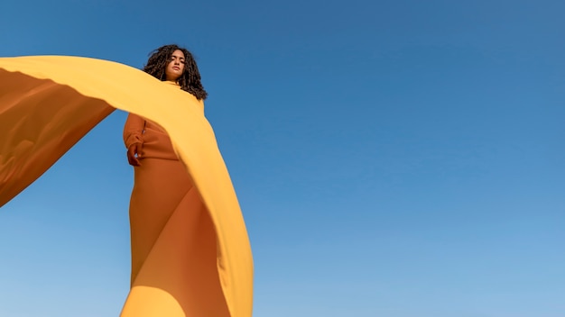 Concepto de libertad con mujer sujetando tela en la naturaleza