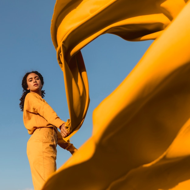 Concepto de libertad con mujer sujetando tela en la naturaleza