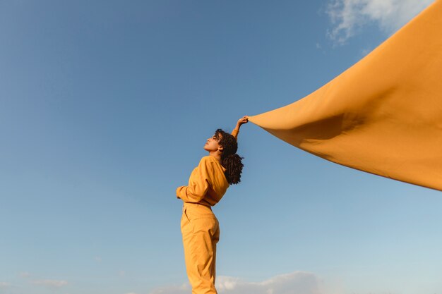 Concepto de libertad con mujer sujetando tela en la naturaleza