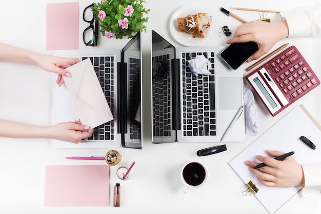 Concepto de lugares de trabajo cómodos para hombres y mujeres. Gadgets en el escritorio blanco