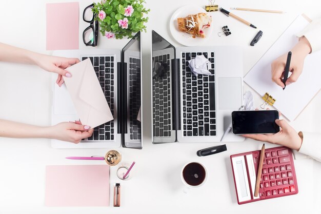 Concepto de lugares de trabajo cómodos para hombres y mujeres. Gadgets en el escritorio blanco