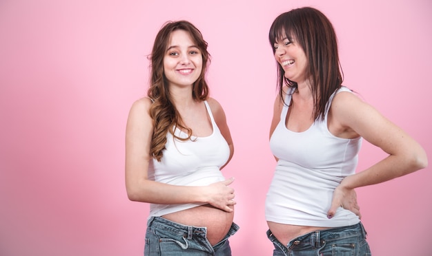 concepto de maternidad, dos mujeres embarazadas con barriga descubierta