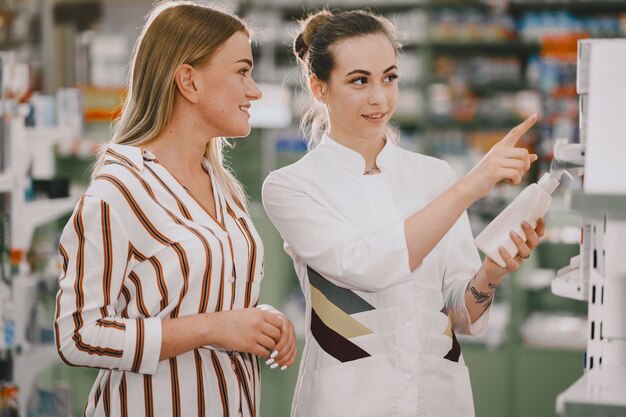 Concepto de medicina, farmacia, salud y personas. La farmacéutica asesora al comprador.