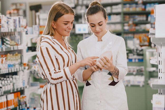 Concepto de medicina, farmacia, salud y personas. La farmacéutica asesora al comprador.