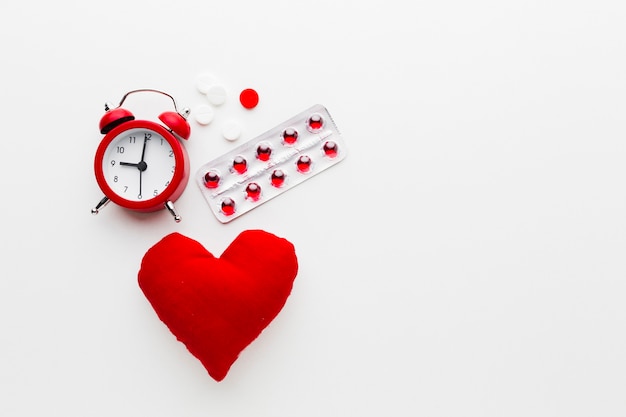 Concepto médico rojo y blanco con reloj y pastillas