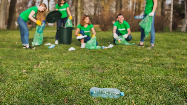 Concepto de medio ambiente y voluntarios con botella en césèd