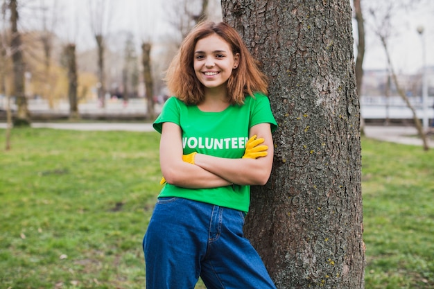 Concepto de medio ambiente y voluntarios con mujer apoyada contra arbol