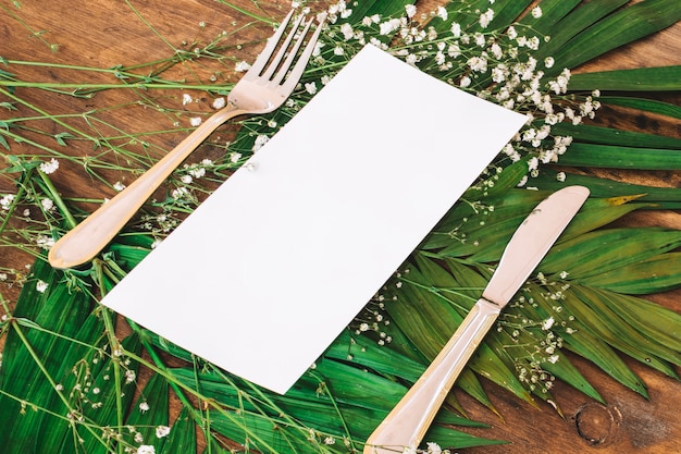 Concepto de menú de boda con cubiertos en hojas