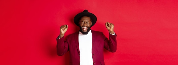 El concepto de moda y fiesta emocionó al hombre negro ganando el premio estrechando las manos levantadas y celebrando victo